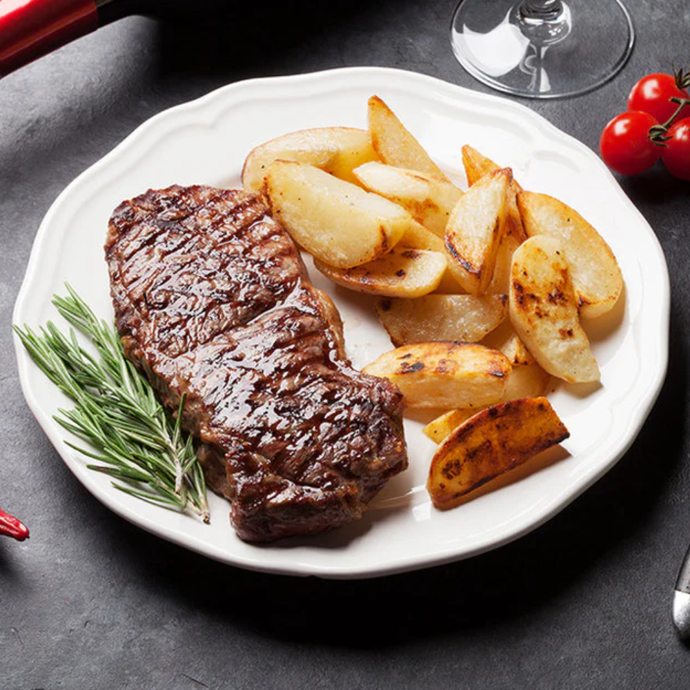 Steak grillé sauce au poivre sur le barbecue et asperges